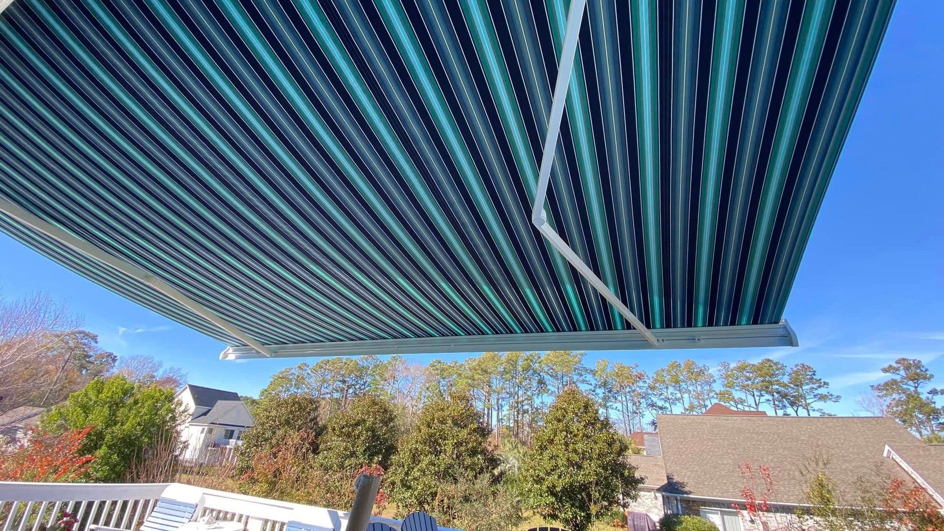 The view from underneath a light and dark blue striped retractable awning.