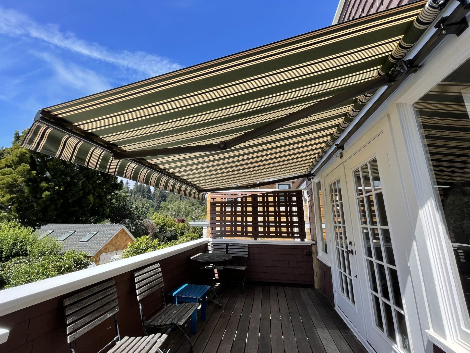 A striped retractable awning covers a deck.