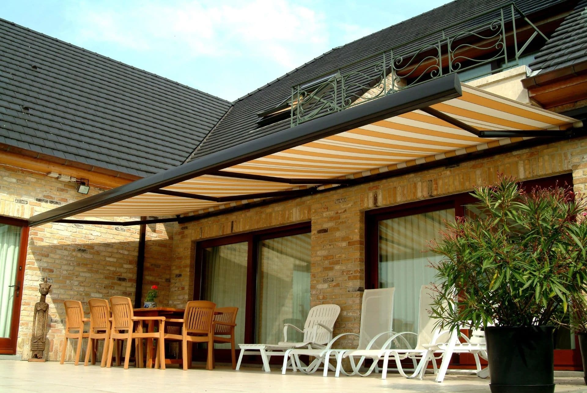 A yellow and white striped retractable outdoor awning by Midwest Home Solutions.