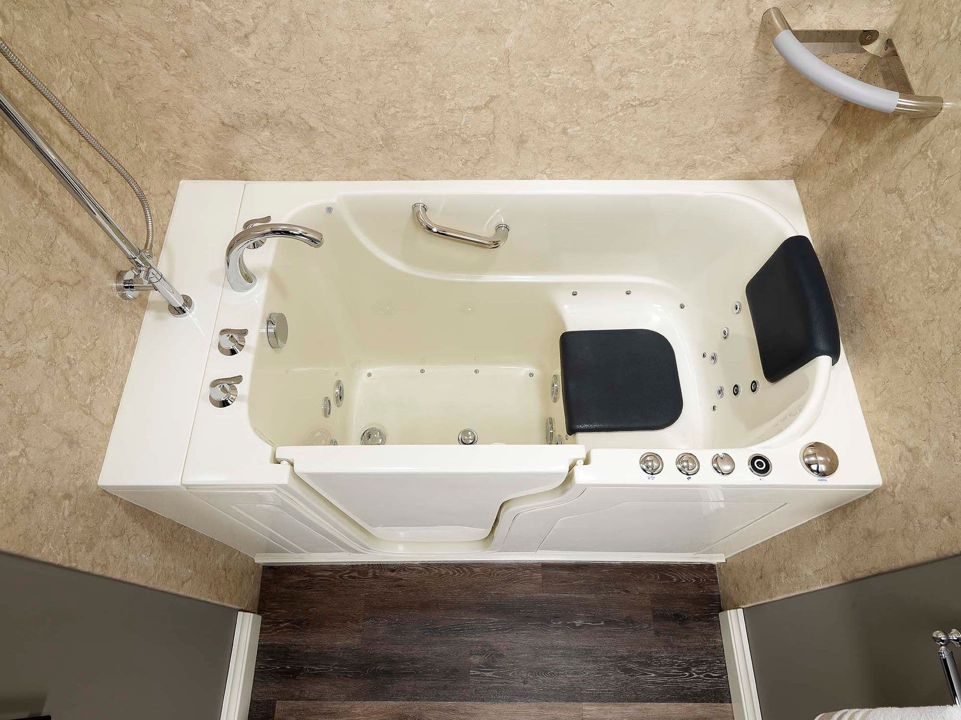 An overhead view of an accessible combination walk-in bathtub and shower with tan textured walls..
