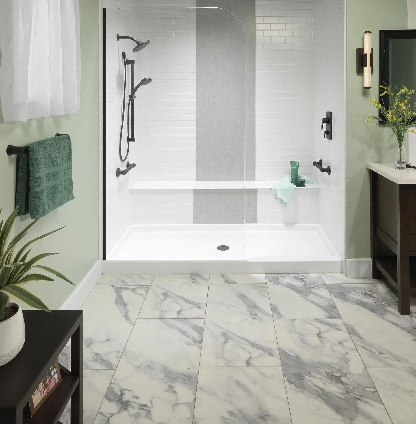 A light green bathroom with white and gray marbled floor and walk-in shower.