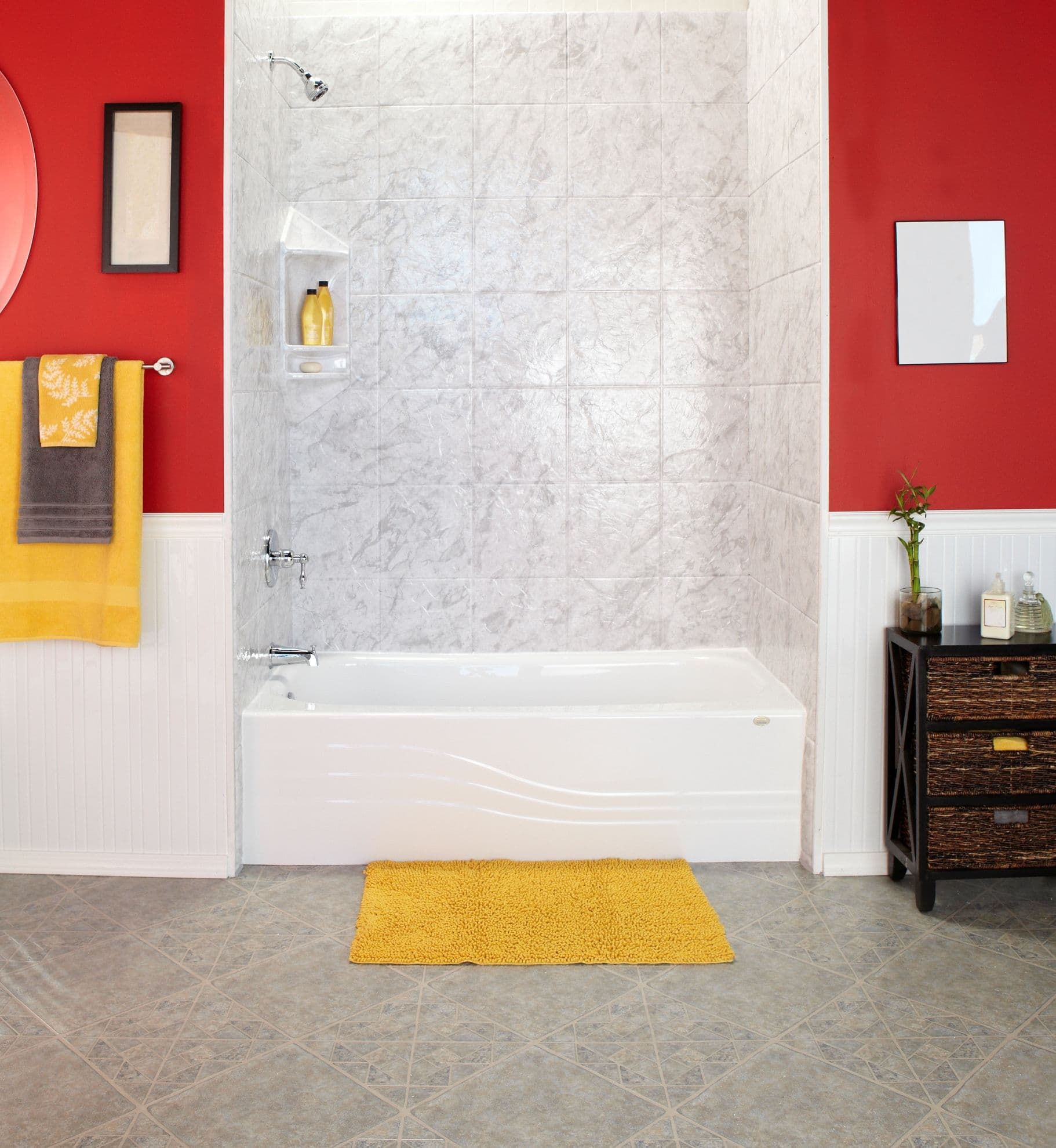 A red bathroom with a combination shower bathtub, gray and white marbled tile walls, and chrome fixtures.