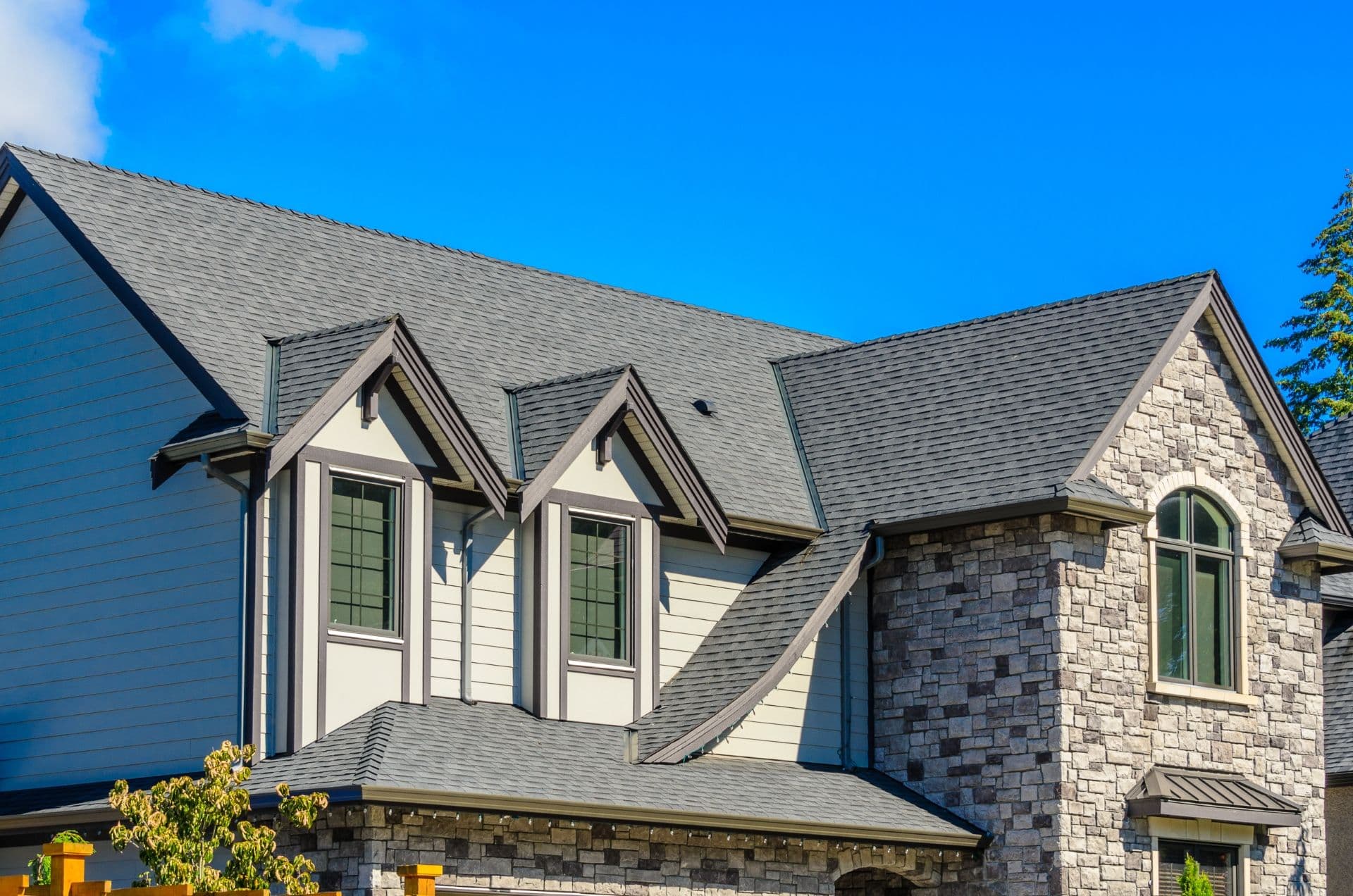 A stone house with new gray roofing.