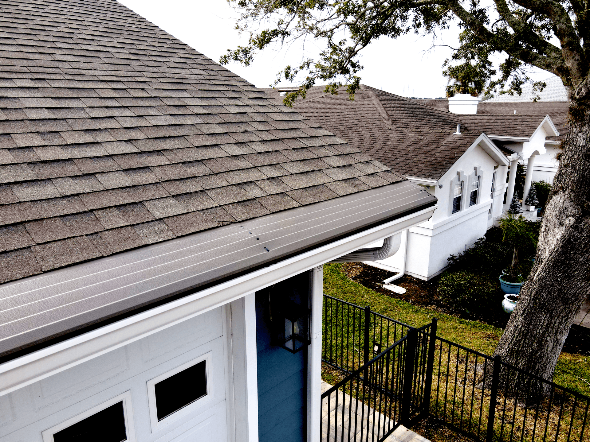 A white house with new, bronze-colored Gutter Helmet gutter covers.