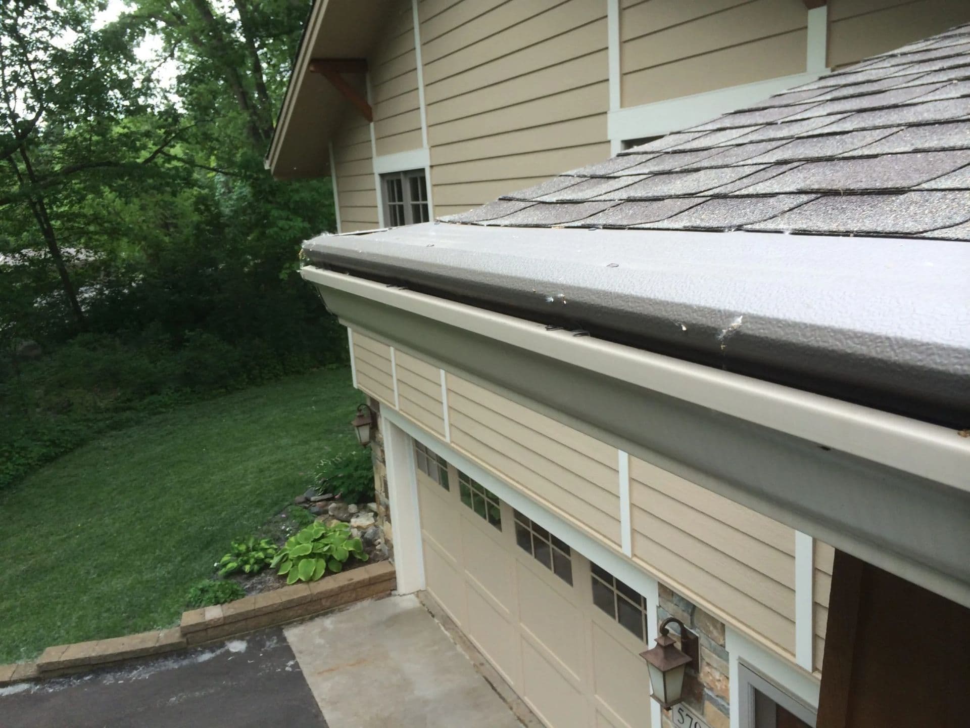 A close-up of a house with new gutters with gutter covers installed by Midwest Home Solutions.