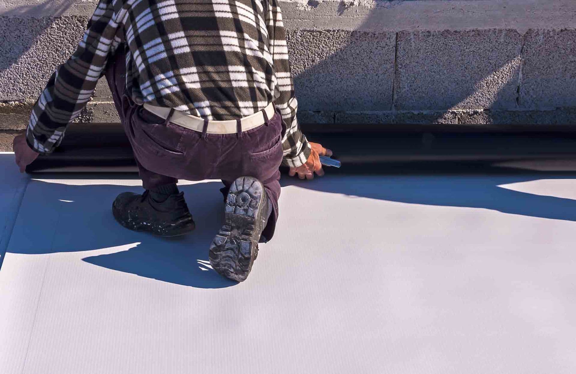 A worker installs new commercial roofing.